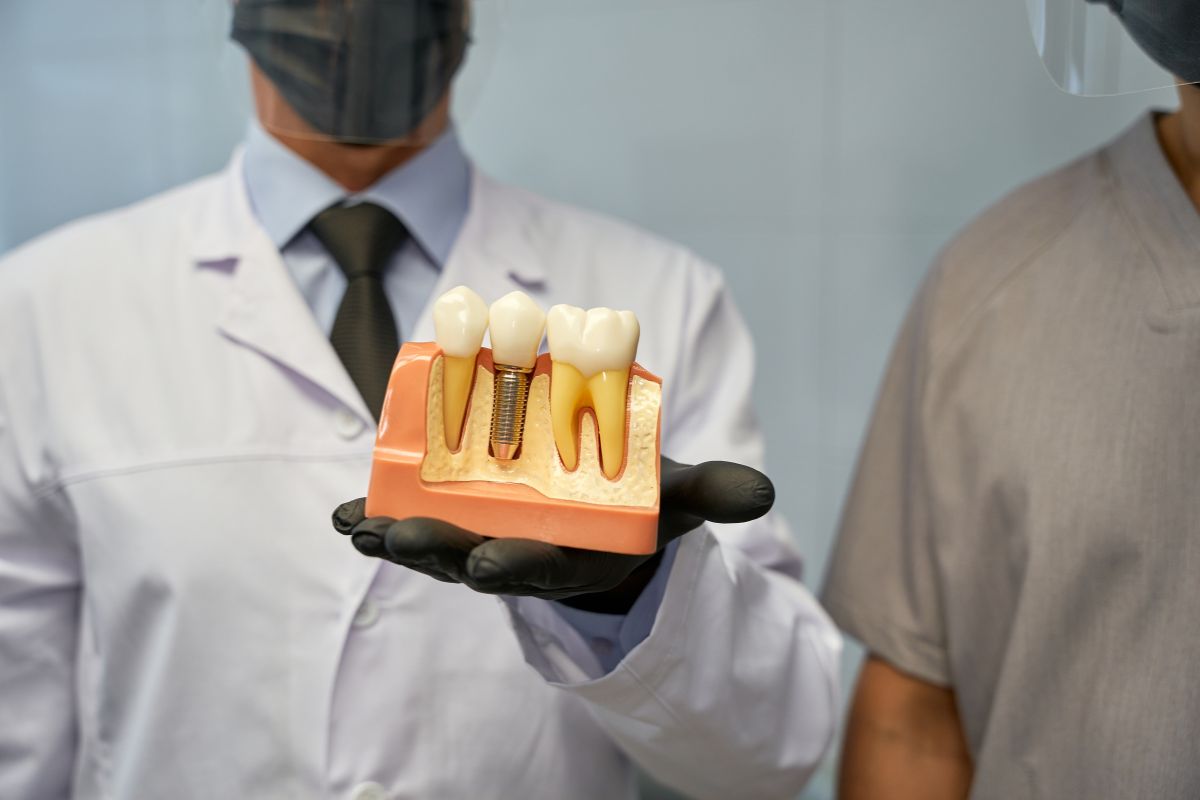 Dentist Showing Dental Implants model to a Teenage patient in Bentonville