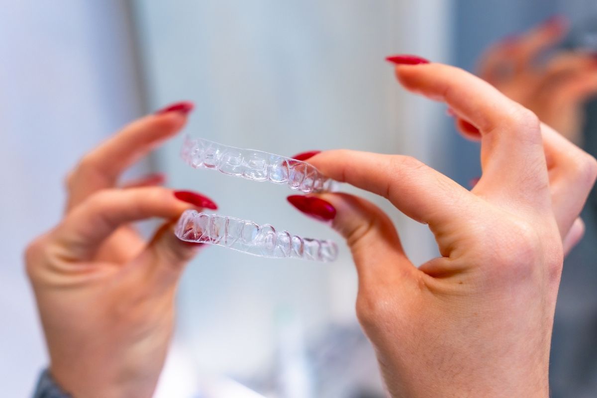 A bentonville cosmetic dentist holding Invisalign aligners
